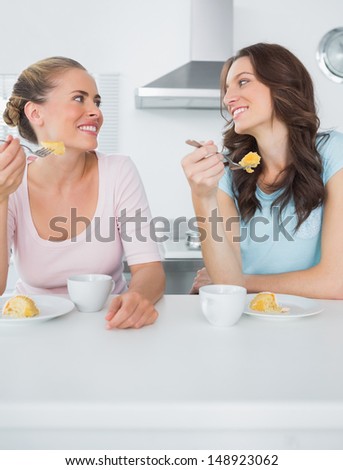 Knowing women eating cake and having coffee together in the kitchen
