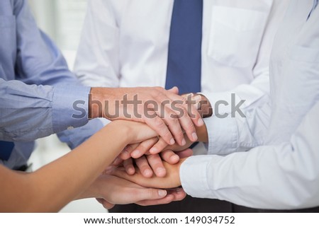 Close up on colleagues hands all together in bright office