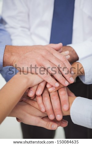 Close up on work teams hands all together in bright office