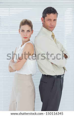 Happy business team posing back to back in bright office