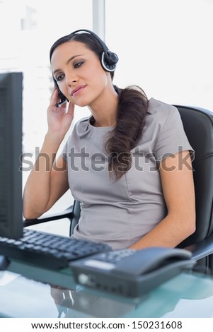 Relaxed attractive secretary wearing headset in her office