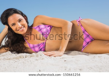Attractive tanned woman sunbathing on the beach