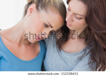 Woman consoling her friend and looking at her