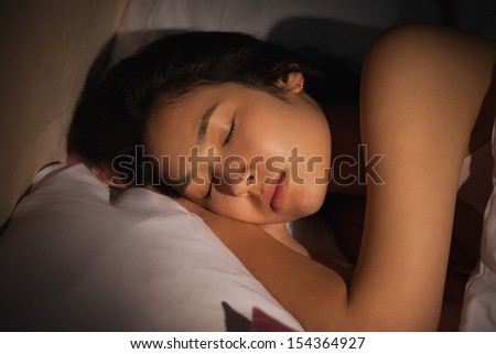 Young asian woman sleeping peacefully at night at home in bedroom