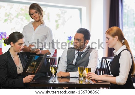 Three business people ordering a dinner in restaurant from waitress