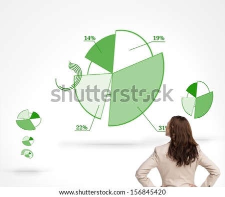 Composite image of businesswoman standing back to camera watching green diagrams on white background