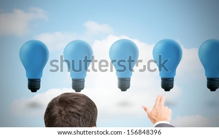 Composite image of businessman pointing with two fingers at blue light bulbs floating in the sky