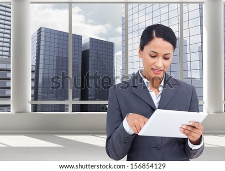 Composite image of saleswoman with her touch screen computer in bright room with windows