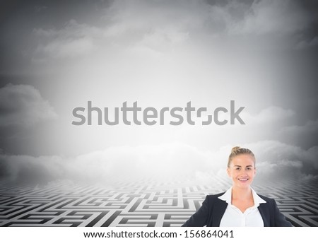 Composite image of blonde businesswoman standing with hands on hips in front of huge maze