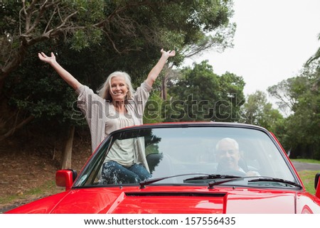 Mature couple having a ride together in red convertible