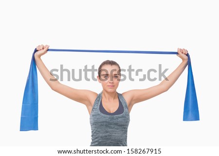 Young woman training using a resistance band looking at camera