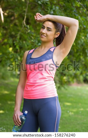 Pretty exhausted woman wearing sportswear posing in a forest