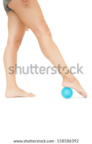 Close up of female legs touching blue massage ball on white background
