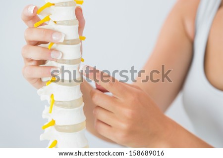Close up of female hand touching skeleton model in bright office