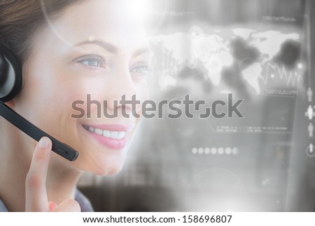Cheerful call center employee looking at futuristic interface hologram touching her headset
