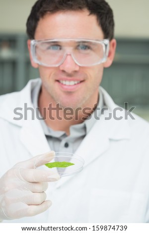 Close-up portrait of a male scientist analyzing a leaf at the laboratory
