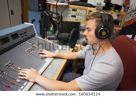 Handsome focused radio host moderating in studio at college
