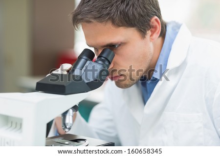 Close-up of a male scientific researcher using microscope in the laboratory