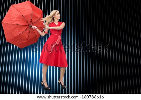 Composite image of beautiful woman posing with a broken umbrella with her leg raised