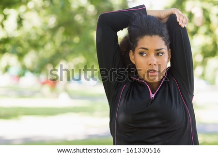 Close up of a healthy young woman stretching her hands during exercise at the park