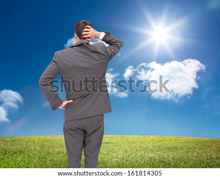 Composite image of young businessman standing back to camera scratching his head on white background