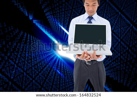 Composite image of portrait of a young businessman showing a laptop