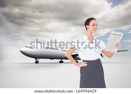 Composite image of cheerful stylish businesswoman holding newspaper while posing