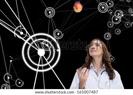 Composite image of happy brunette doctor throwing apple