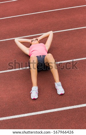 High angle view of a sporty woman suffering from headache on the running track