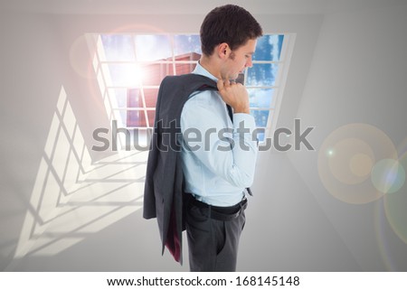 Serious businessman holding his jacket against server tower seen through window