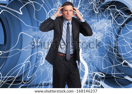 Stressed businessman with hands on head against abstract blue design in futuristic structure