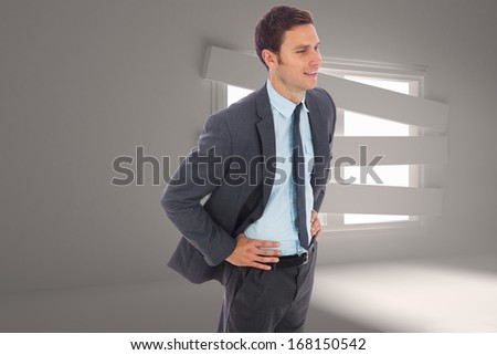 Cheerful businessman standing with hand on hip against digitally generated room with bordered up window