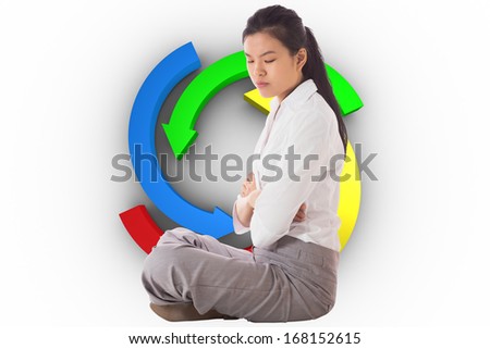 Businesswoman sitting cross legged with arms crossed against colorful arrow circle