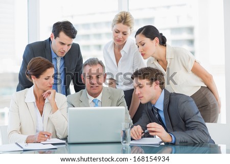 Group of content business colleagues with laptop at office desk