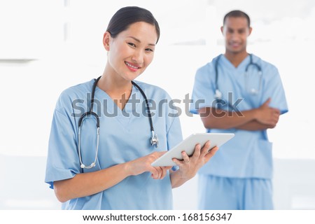 Portrait of a beautiful female surgeon holding digital tablet in the hospital