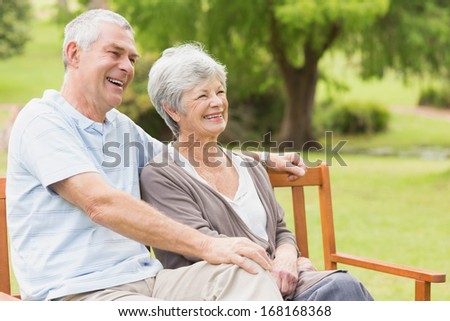 Side view of senior woman and man sitting on bench at the park