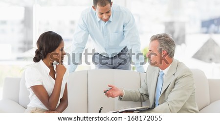 Salesman showing clients where to sign the deal in the office