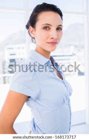 Portrait of a serious young businesswoman standing in a bright office