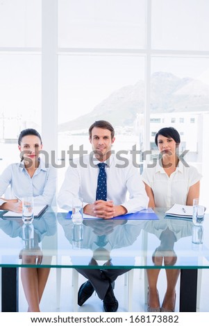 Portrait of smartly dressed young executives sitting at desk in a bright office