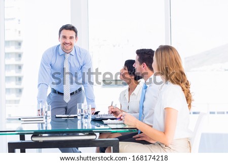 Smartly dressed young executives around conference table in office