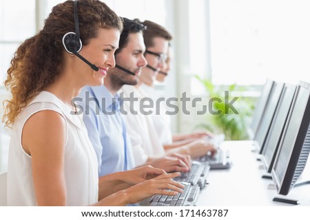 Customer service representatives working at desk in office