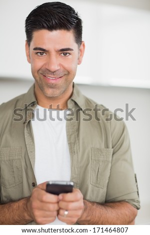 Portrait of a smiling man text messaging at home