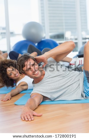 Portrait of smiling people doing pilate exercises in the fitness studio