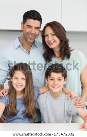 Portrait of a happy family of four in the kitchen at home
