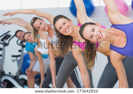 Portrait of people doing power fitness exercise at yoga class in fitness studio