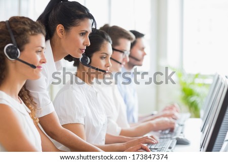 Side view of female manager assisting her staffs in a call center