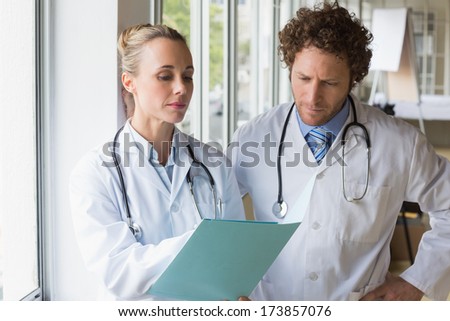 Doctors discussing over file in hospital