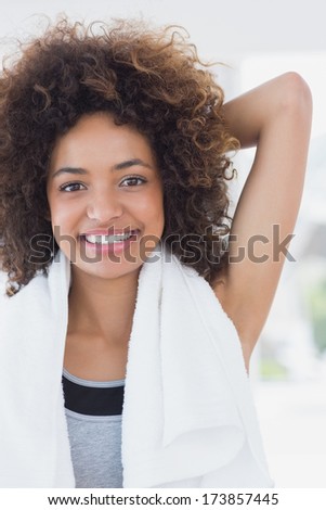 Portrait of a sporty young woman stretching hand behind back in fitness studio