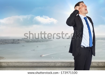 Thinking businessman scratching head against balcony overlooking city