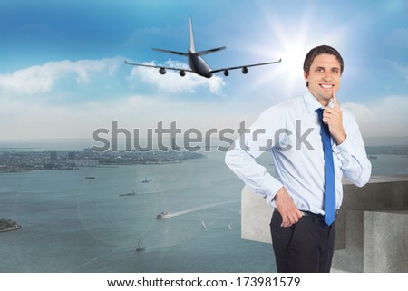 Thinking businessman touching his chin against balcony overlooking city